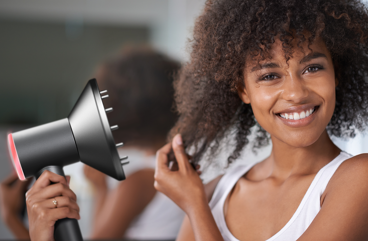  A black woman with natural curls is using the Goolioo high-speed hair dryer to blow dry her hair.